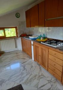 una cucina con armadi in legno e pavimento in marmo di Villa dolce a Massa