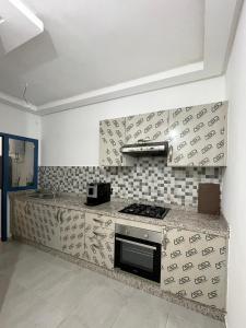 uma cozinha com um fogão e uma bancada em COSTAMAR em Martil