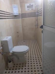W łazience znajduje się biała toaleta i prysznic. w obiekcie Résidence Nydia w mieście Ras El Ma