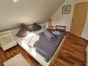a large bed in a room with wooden floors at Ferienwohnung Tukan in Walsrode