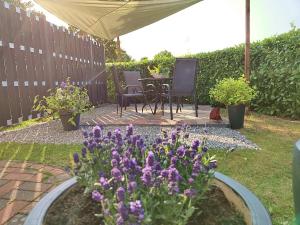einen Garten mit lila Blumen, einem Tisch und Stühlen in der Unterkunft Ferienwohnung Tukan in Walsrode