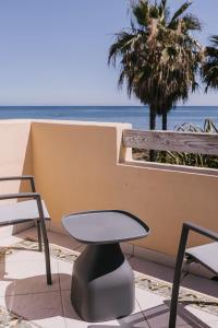 una mesa y sillas frente a la playa en Luxury sea views Townhouse Marbella, en Marbella