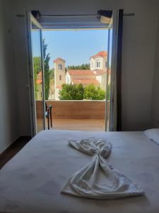 a bedroom with a bed with a large window at Vila Lefteria in Këlcyrë