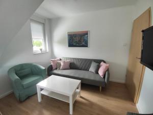 ein Wohnzimmer mit einem Sofa und einem Stuhl in der Unterkunft Ferienwohnung Tukan in Walsrode