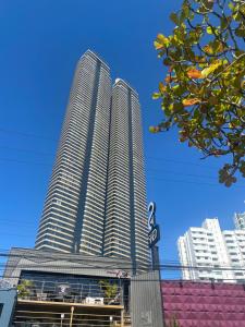 dos edificios altos en una ciudad con un cielo azul en APTO. BEIRA MAR EM BAL. CAMBORIU, en Balneário Camboriú