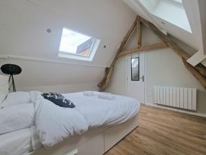 ein Schlafzimmer mit einem weißen Bett und einem Fenster in der Unterkunft Maison T3 Mérignies in Mérignies