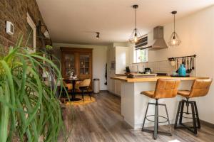 a kitchen with a counter and bar stools at Vakantiewoning Le Garaazje in 's-Gravendeel
