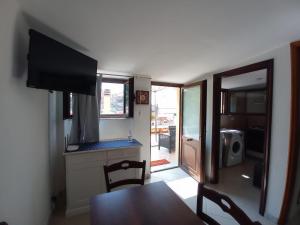 a dining room with a table and a tv in a room at Blasu Home in Maratea