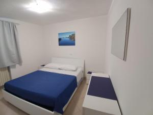 a bedroom with a bed with a blue blanket at Blasu Home in Maratea
