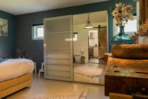 a bedroom with a large glass cabinet with a mirror at Vakantiewoning Le Garaazje in 's-Gravendeel