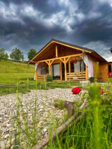 una casa en una colina con un cielo nublado en Căsuțele din Poiană, en Satu Şugatag