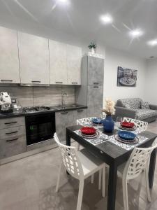 une cuisine avec une table et des chaises blanches ainsi qu'une salle à manger dans l'établissement La casetta di salvuccio, à Palerme