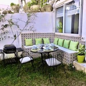 a patio with a table and chairs in the grass at Sunsets at Fully Equipped Big APT at the Beach in La Marsa
