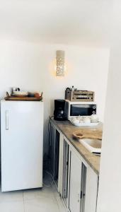 a kitchen with a white refrigerator and a microwave at Sunsets at Fully Equipped Big APT at the Beach in La Marsa