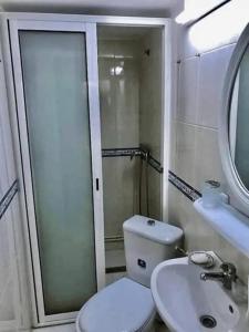 a bathroom with a toilet and a sink and a mirror at Sunsets at Fully Equipped Big APT at the Beach in La Marsa