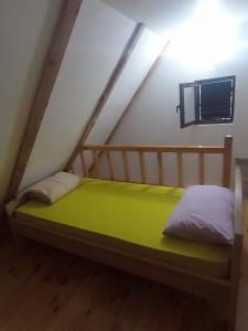 a small bed in a room with a roof at Katun Mokra in Podgorica