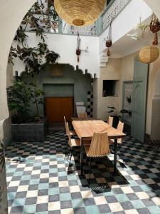 una stanza con tavolo e sedie su un pavimento a scacchi di Riad Nadara, superbe riad au coeur de la medina! a Marrakech