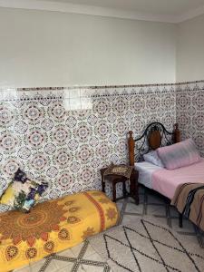 1 Schlafzimmer mit 2 Betten und einer Wand mit Fliesen in der Unterkunft Une maison au centre de l'ancienne Médina in Marrakesch + 2 Fotos