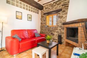 a red leather couch in a living room with a fireplace at Paraje la Suerte Apartamento Crisantemo in Adra