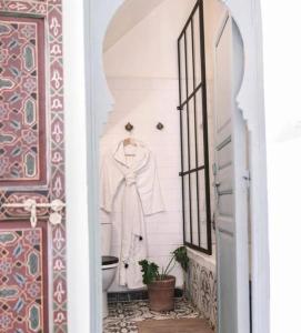 un bagno con una camicia bianca appesa a un muro di Riad Nadara, superbe riad au coeur de la medina! a Marrakech Altre 43 foto