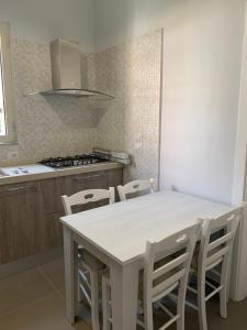 uma cozinha com uma mesa branca e cadeiras em La Masseria di Felicetta em SantʼAnastasia