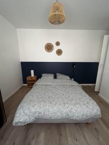 a bedroom with a bed and a blue and white wall at Appartement, Mussidan in Mussidan