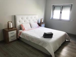 Schlafzimmer mit einem großen weißen Bett und einem Fenster in der Unterkunft Market Apartment - VPA in Vila Praia de Âncora