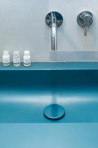 um lavatório com uma torneira e três frascos de medicamentos em Contrada del Nonno Apartments (city center - private parking on-site) em Rovinj