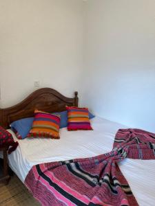 ein Bett mit zwei Kissen und einer Decke darauf in der Unterkunft Une maison au centre de l'ancienne Médina in Marrakesch