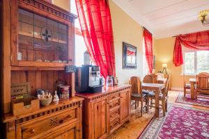 a kitchen with wooden cabinets and red curtains at Alte Villa G&auml;stehaus in L&uuml;deritz
