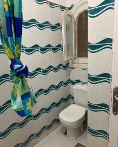 a bathroom with a toilet and a shower curtain at Marina 2 chalet lake front in El Alamein