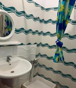 a bathroom with a sink and a shower curtain at Marina 2 chalet lake front in El Alamein