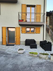 ein Gebäude mit orangefarbenen Türen und schwarzen Möbeln sowie einem Balkon in der Unterkunft Casa Vacanza Relax Sondrio in Sondrio