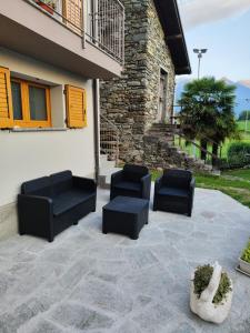 un patio con 2 sedie nere e un edificio di Casa Vacanza Relax Sondrio a Sondrio