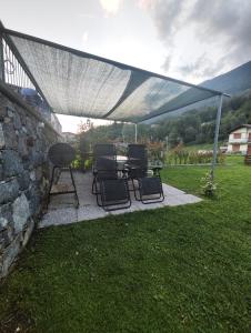 un patio con tavolo e sedie sotto una tenda. di Casa Vacanza Relax Sondrio a Sondrio