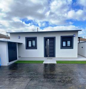 Biały dom z czarnymi oknami i podjazdem w obiekcie LOFT VILLALUCIA w mieście Conil de la Frontera