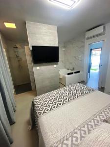 a bedroom with a bed and a tv on a wall at LOFT VILLALUCIA in Conil de la Frontera +12 photos