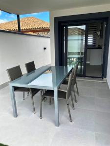 szklany stół i krzesła na patio w obiekcie LOFT VILLALUCIA w mieście Conil de la Frontera