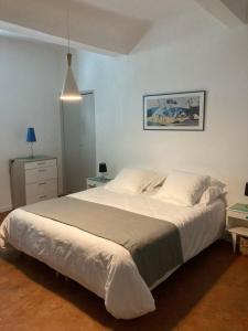 a bedroom with a large white bed in a room at La Célestine in Valensole