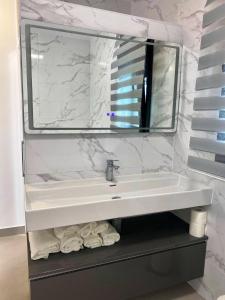 a bathroom with a sink and a mirror and towels at LOFT VILLALUCIA in Conil de la Frontera