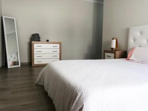 1 dormitorio con cama blanca y vestidor en Market Apartment - VPA, en Vila Praia de Âncora