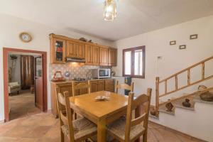 a kitchen and dining room with a wooden table at La Dimora degli Dei in Piras