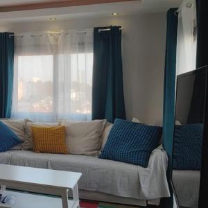 salon z kanapą z niebieskimi zasłonami w obiekcie Rainbow 7th floor penthouse apartment w mieście İncirli