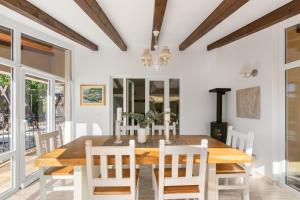 a dining room with a wooden table and white chairs at Kastelir in Kaštelir