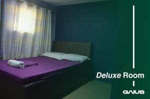 un dormitorio con una cama morada con una habitación morada me cavo en Gaius Inn, en Manila