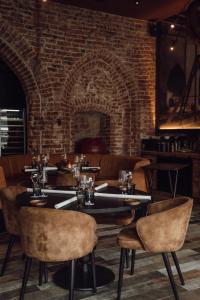 a restaurant with tables and chairs and a brick wall at Broederenklooster in Zutphen