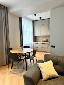 a living room with a table and a kitchen at Silver Apartment in Daugavpils