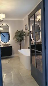 的住宿－No.10 Kwiatonowice，一间带大浴缸和镜子的浴室
