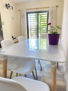 a white table with white chairs and a potted plant on it at Depto frente a Palmares Shopping Mall in Godoy Cruz