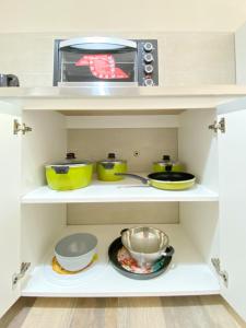 a kitchen with white shelves and a microwave at Depto frente a Palmares Shopping Mall in Godoy Cruz